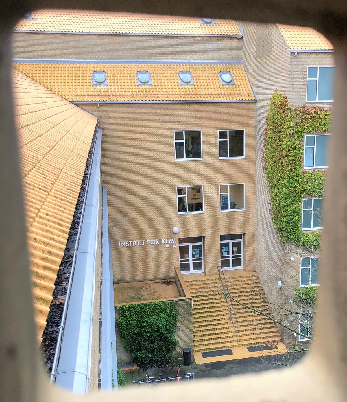 Instituttets hovedindgang set fra udluftningen under loftet i modsatte bygning.